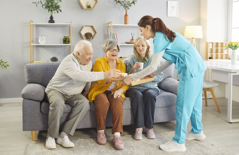 A caregiver warmly serving tea to smiling residents in a bright, cozy living room